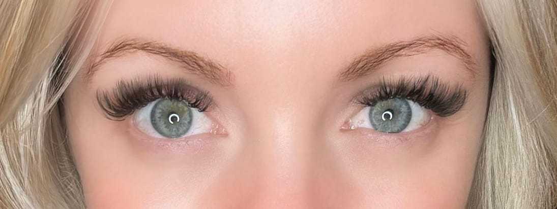 Close-up of a person's blue eyes with long, thick eyelashes.